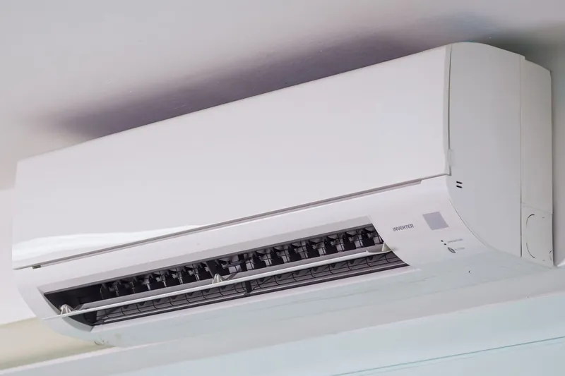 Condizionatore split bianco montato in alto su una parete